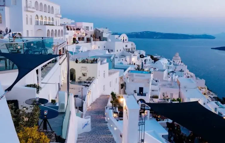 Vertical high-angle shot of white buildings in Santorini, Greece, showcasing the allure of Mediterranean Coastal Getaways.